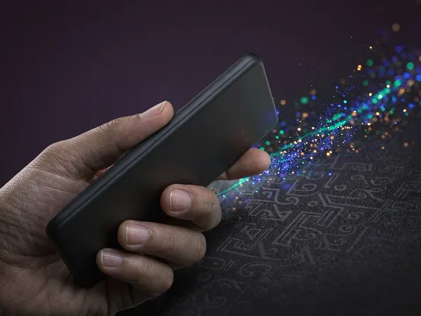 98s + Hand holding a smartphone with colourful light particles